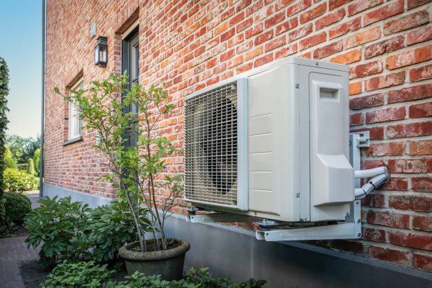 An air-source heat pump attached to wall